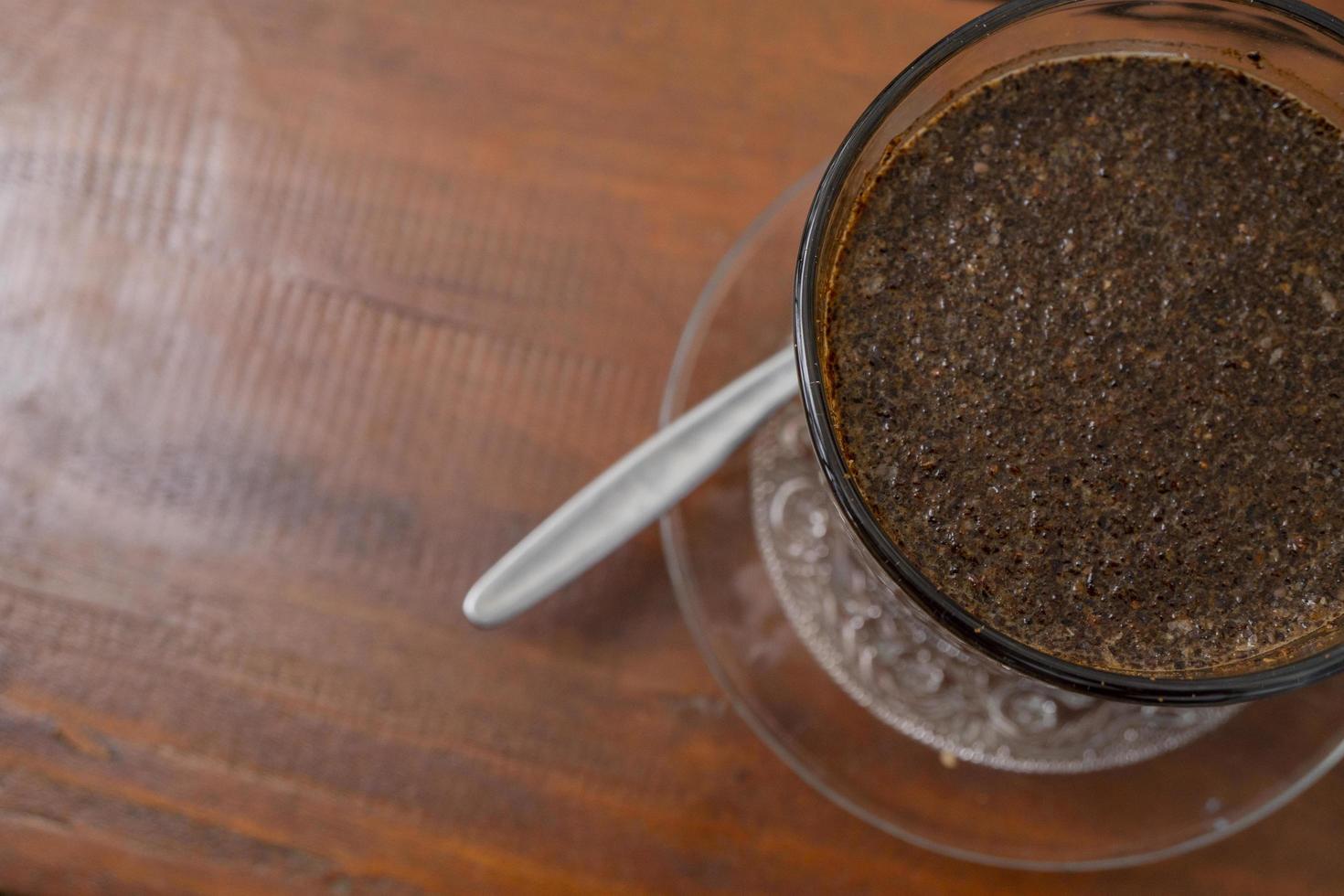 Close up photo a cup of arabica coffee with spoon from high angle. The photo is suitable to use for coffee shop background, menu poster and coffee content media.