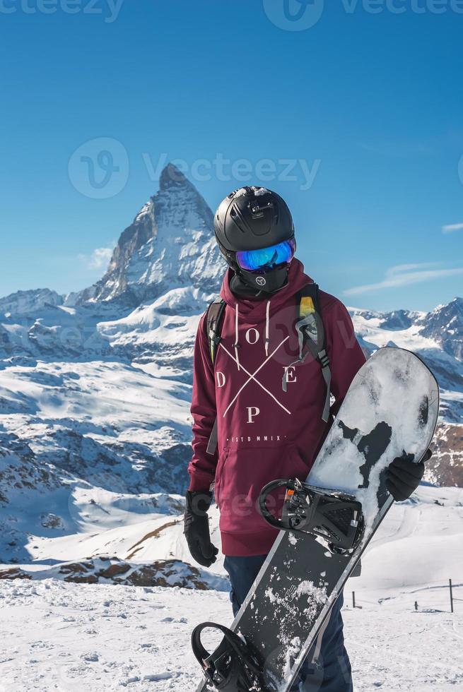 joven snowboarder gasto invierno Días festivos en zermatt, cerca el famoso materia cima. masculino posando en suizo Alpes para el Snowboarding estación. foto