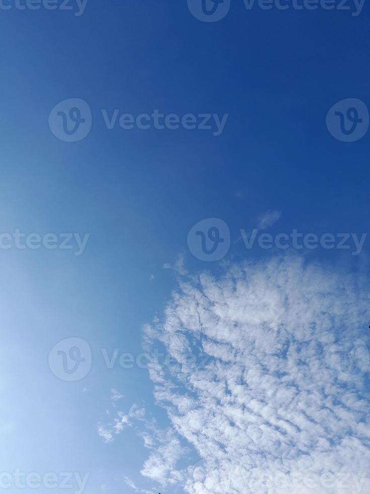 Beautiful white clouds on deep blue sky background. Large bright soft fluffy clouds are cover the entire blue sky. photo