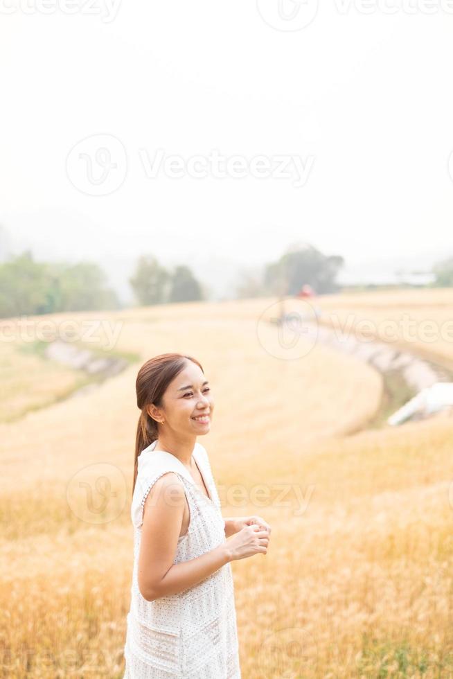 joven asiático mujer en blanco vestidos en el cebada arroz campo foto