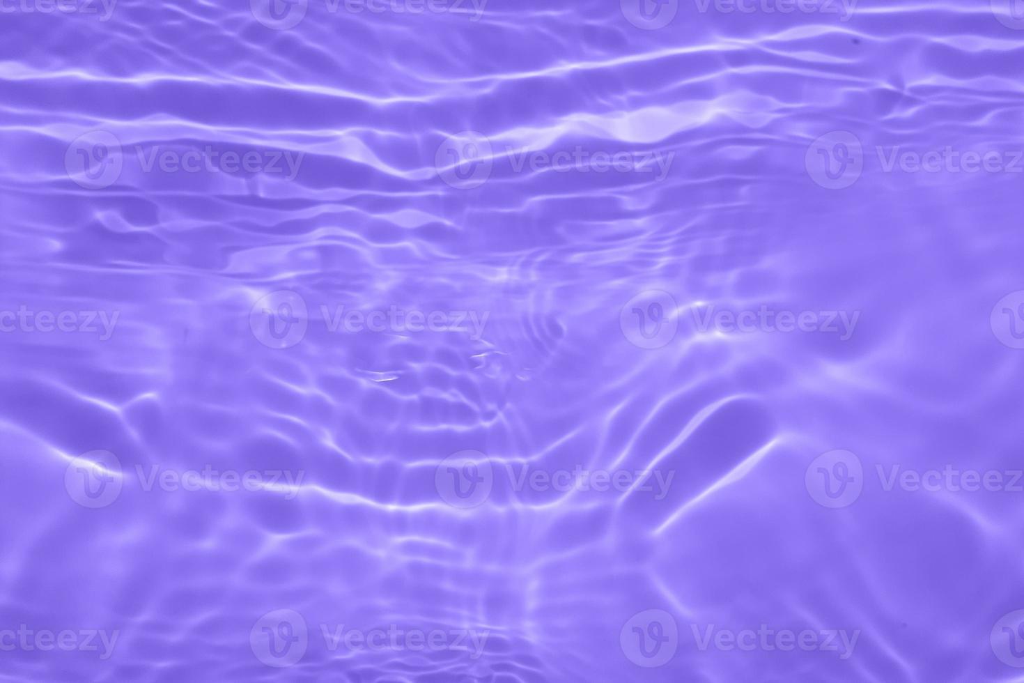 Defocus blurred transparent purple colored clear calm water surface texture with splashes and bubbles. Trendy abstract nature background. Water waves in sunlight with copy space. Purple velvet. photo