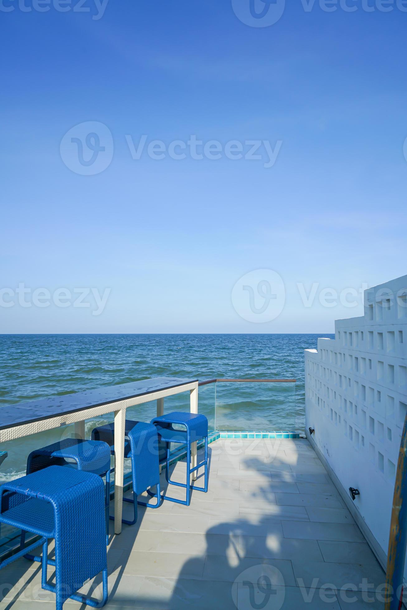 desk and bar stool near swimming pool with sea background 21956567