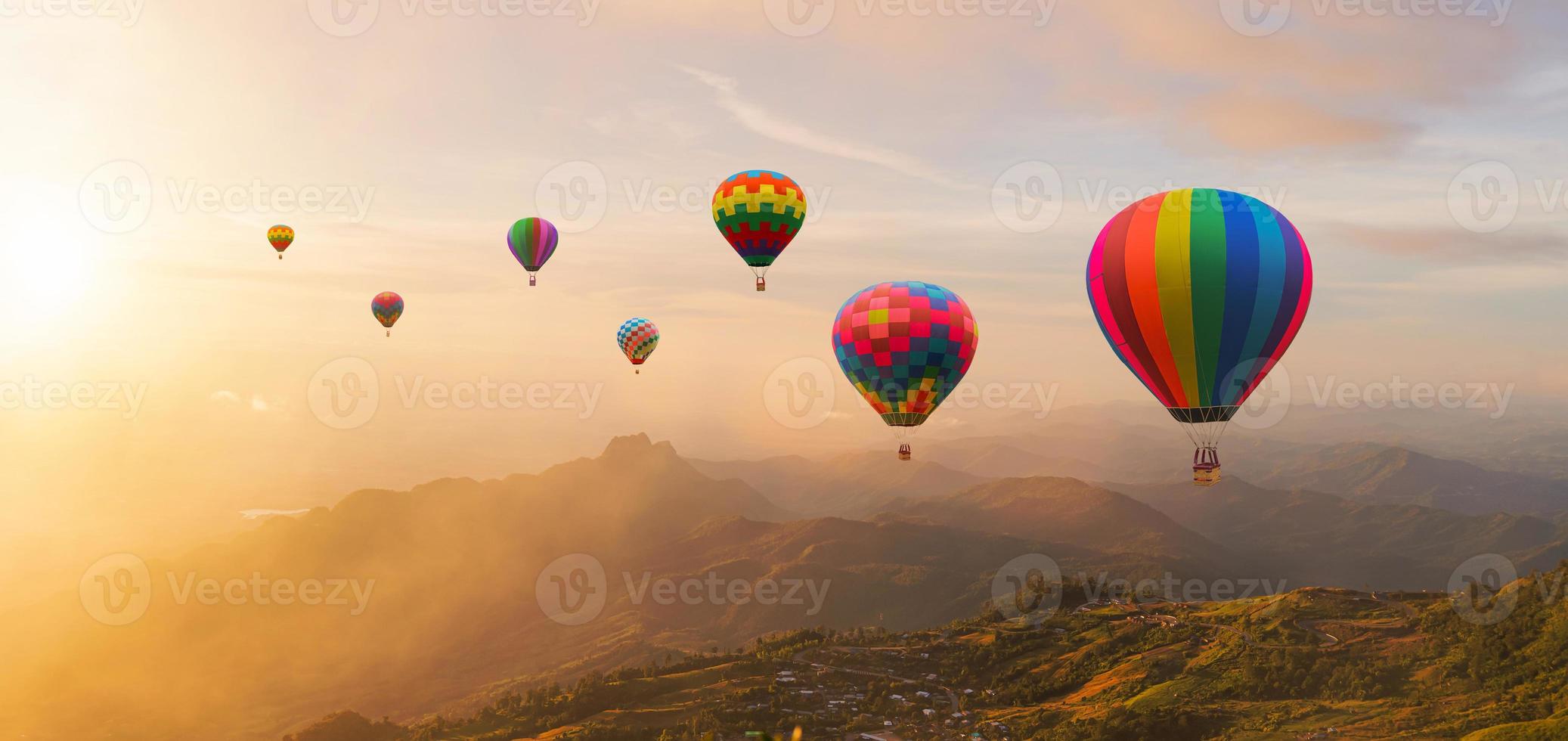 vistoso caliente aire globos volador encima montaña a amanecer cielo antecedentes. viaje natural antecedentes. foto