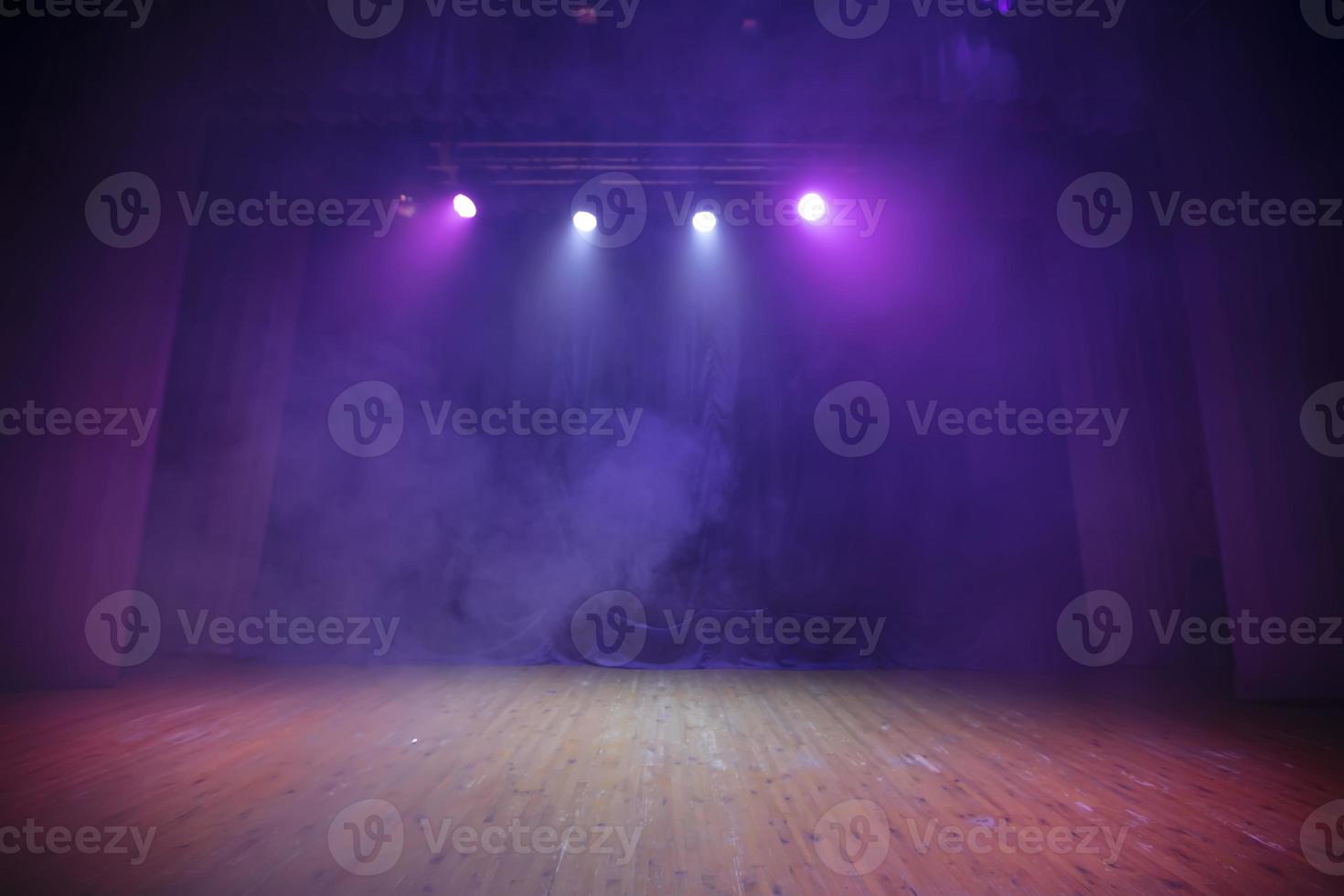 A stage for performances with purple curtains, wood floor and all in smoke. Theatrical background. photo
