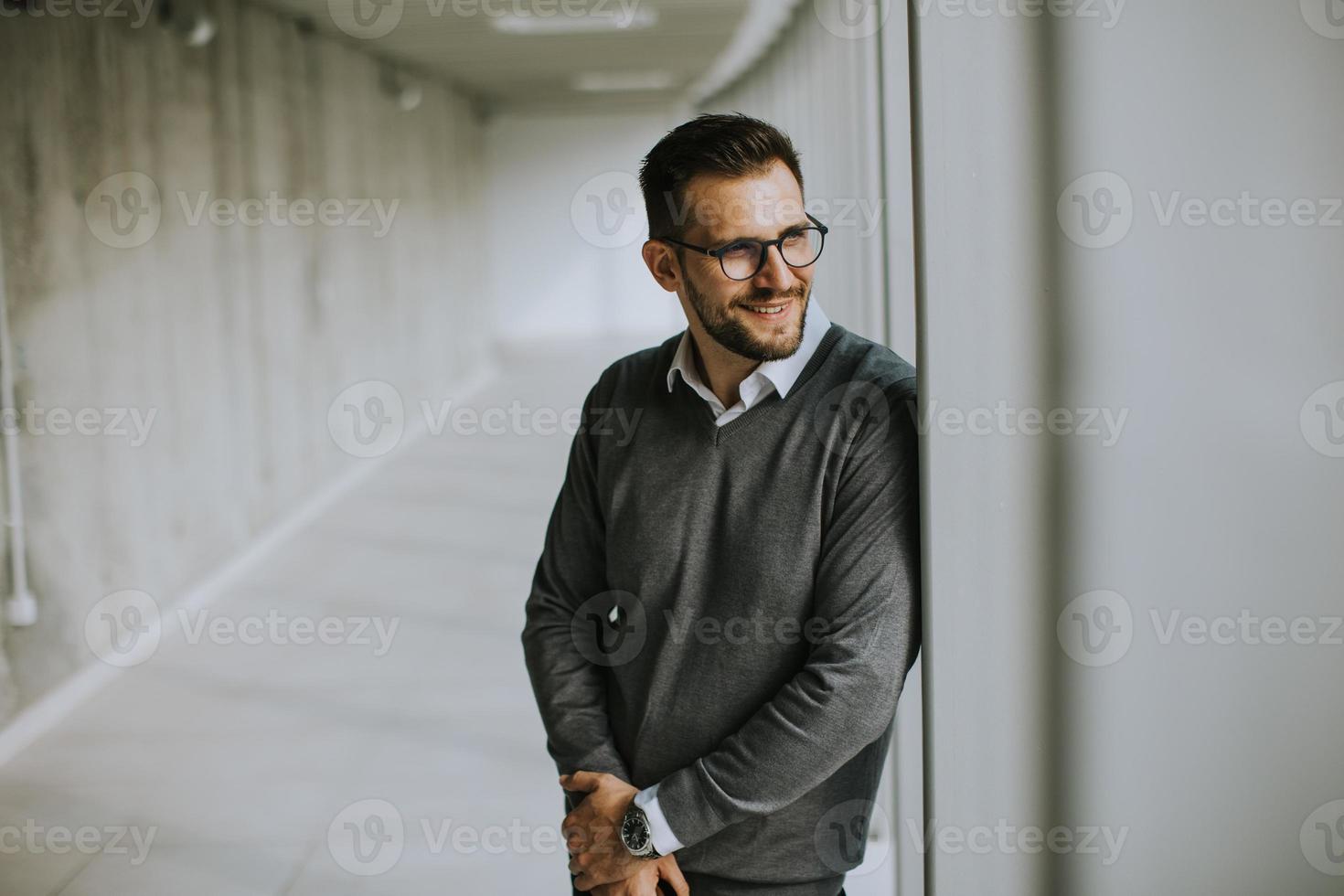 joven moderno empresario en pie en el oficina corredor foto