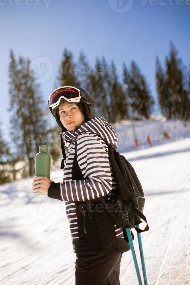 Young woman enjoing winter day of skiing fun in the snow photo