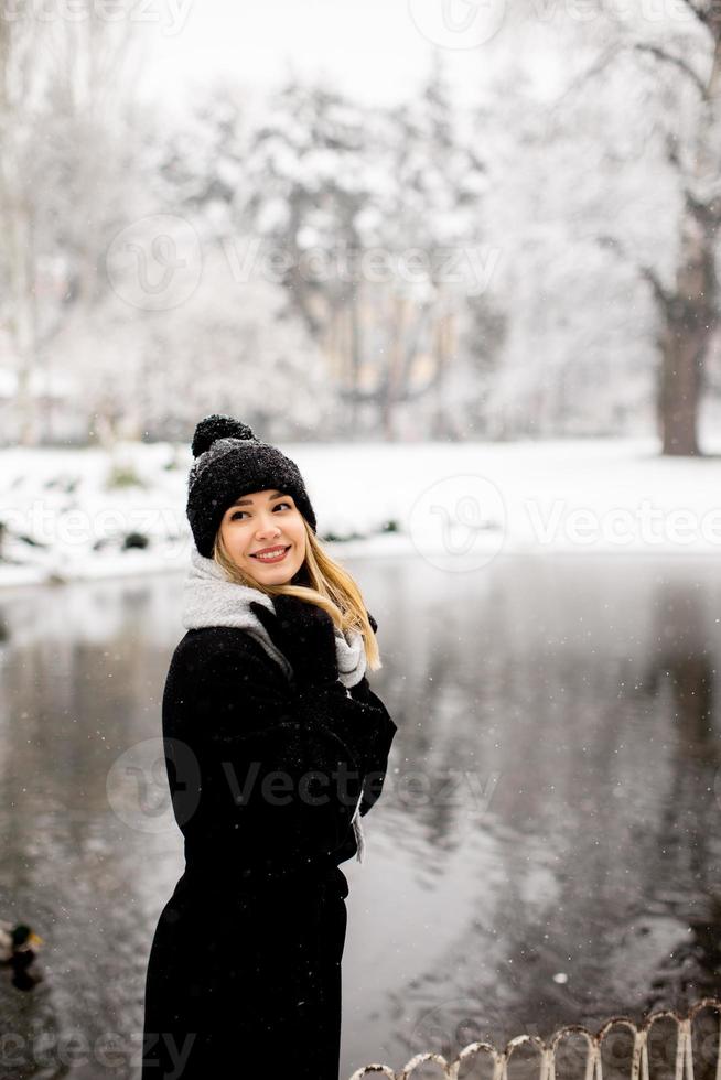 Young woman in warm clothes enjoying in snow photo