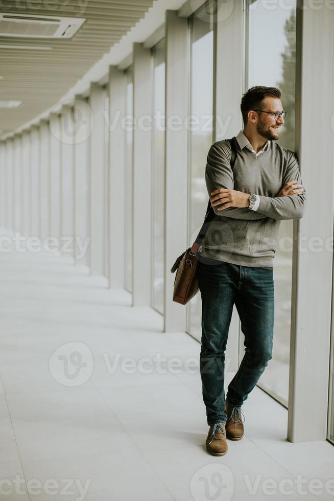 joven moderno empresario en pie en el oficina corredor foto