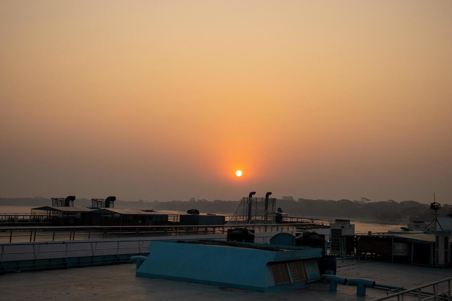 Beautiful Dawn with a sunrise view on a ship. Twilight view with sunset and water vessel. Beautiful sunset view on a ship at dusk time. Sky and tree horizon with sunrise scenery from a launch. photo