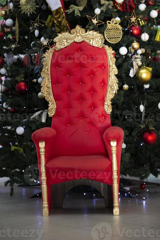 Red throne at the christmas tree. Armchair for Santa Claus. photo