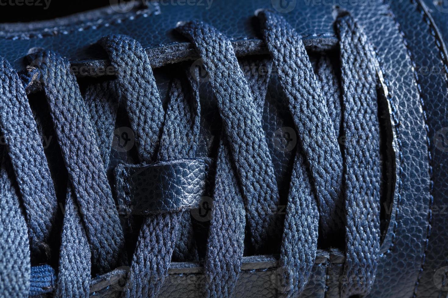 Part of a blue boot with laces. A fragment of leather shoes. A piece of sneaker. photo