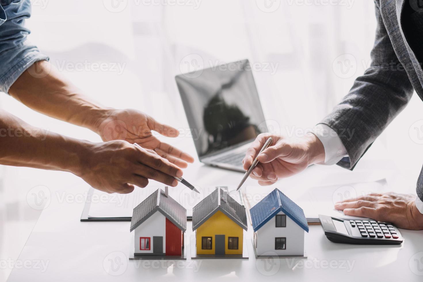 agente de bienes raíces que presenta y consulta al cliente para la toma de decisiones firmar un acuerdo de formulario de seguro, modelo de compra y venta de casa, en relación con la oferta de préstamo hipotecario y el seguro de la casa foto