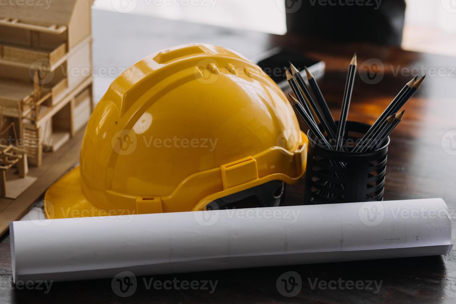 Image of engineering objects on workplace with three partners interacting on background photo