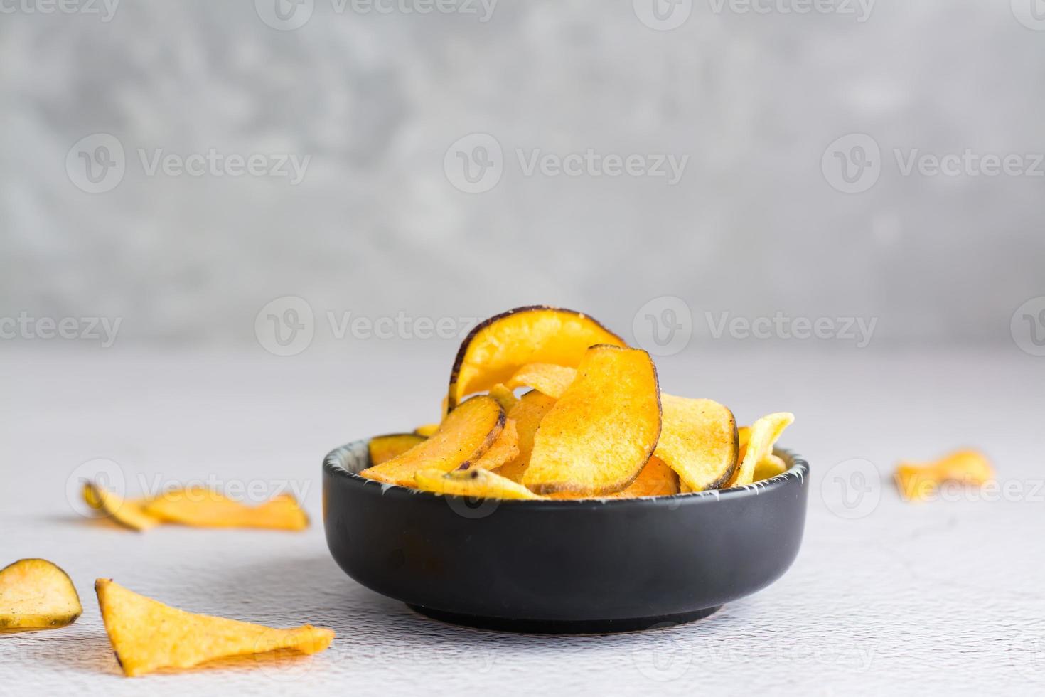 Appetizing sweet potato chips in a bowl on the table. Homemade snack. Copy space photo