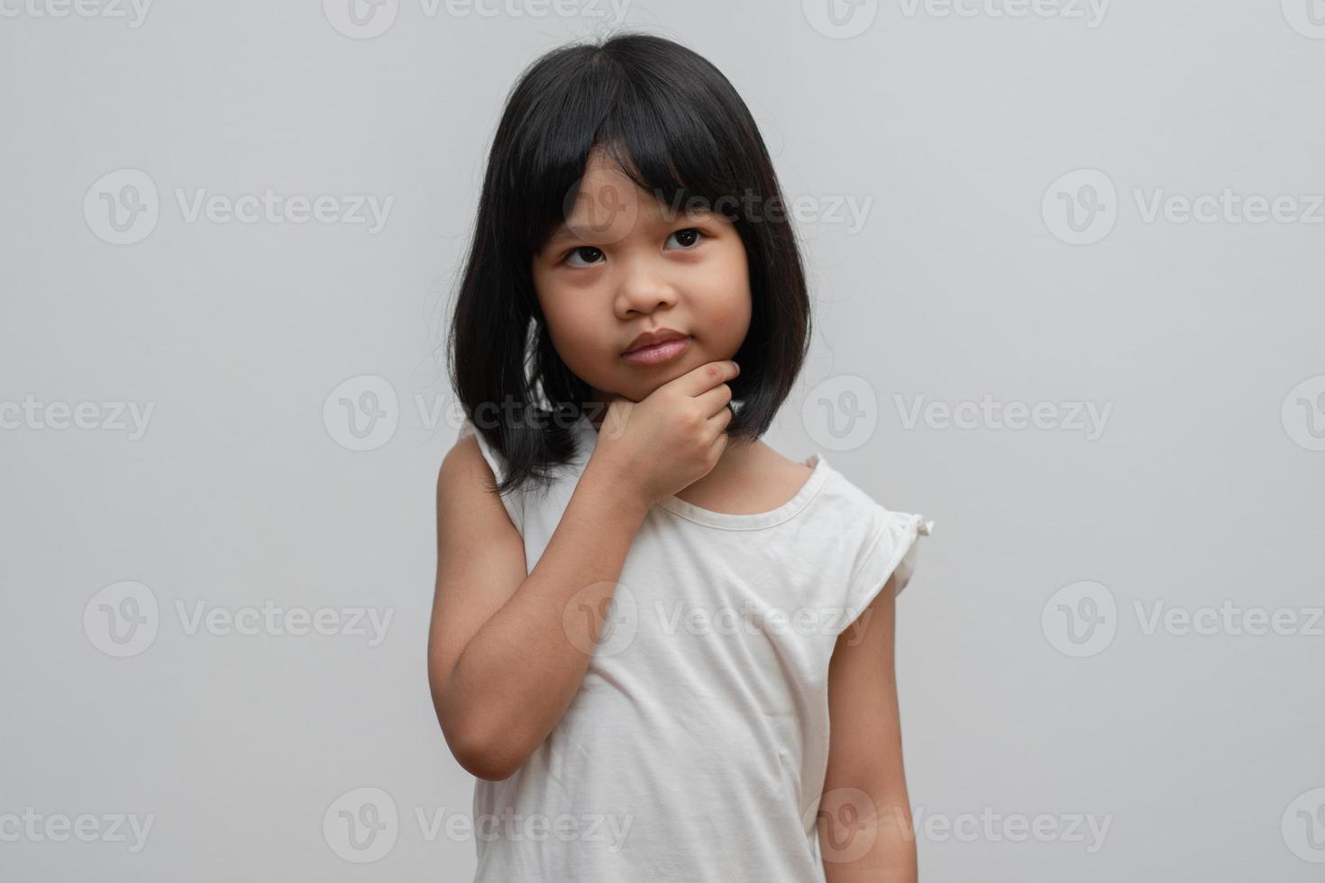 Portrait of Asian child 5 year old and to collect hair and Place her hands on her chin and make thinking pose on isolated white background, She is Happiness, radiance in youth, Education Concept photo