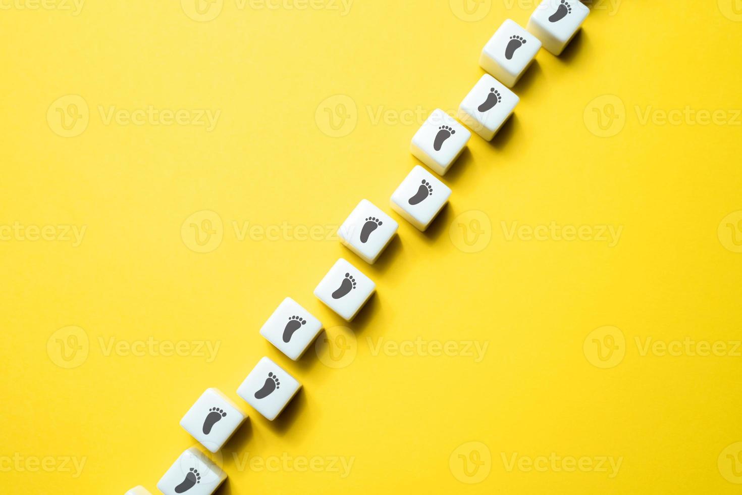 Path of footprints on the blocks. Trust in their ability to navigate it successfully. Each step brings closer to destination. Progress and success are achieved by taking one small step at a time. photo