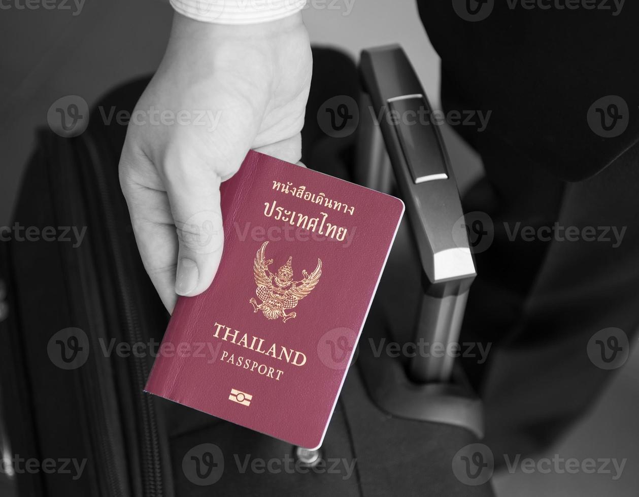 Hand holding Thai passport, ready to travel photo