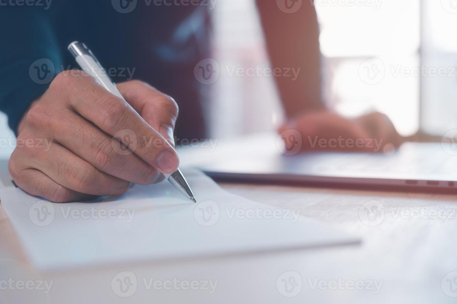 businessman taking note on white paper with pen on table in office, meeting brainstorming concept, writing business plans and workflow photo