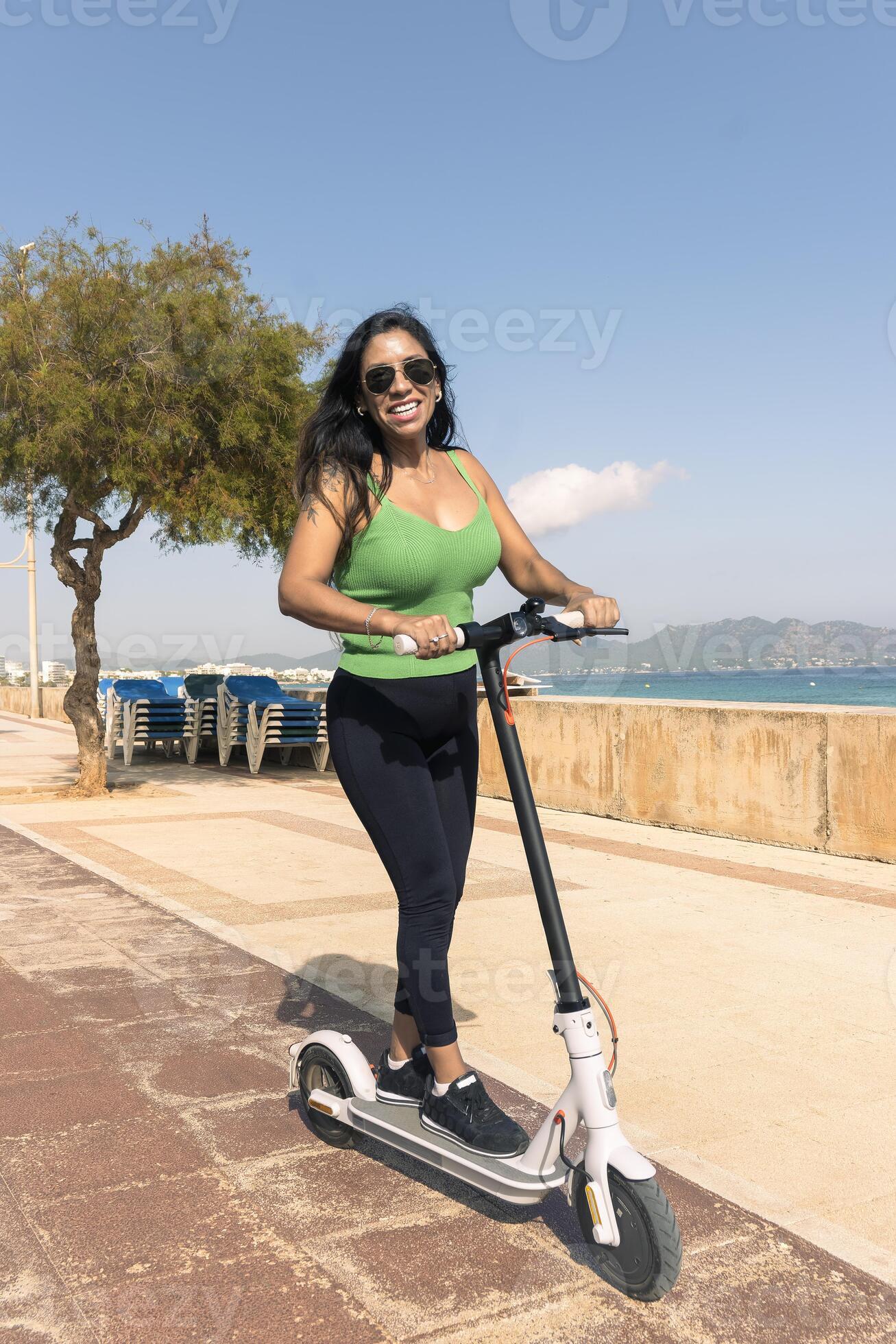 Woman riding electric scooter, happy and summer ride at tropical island