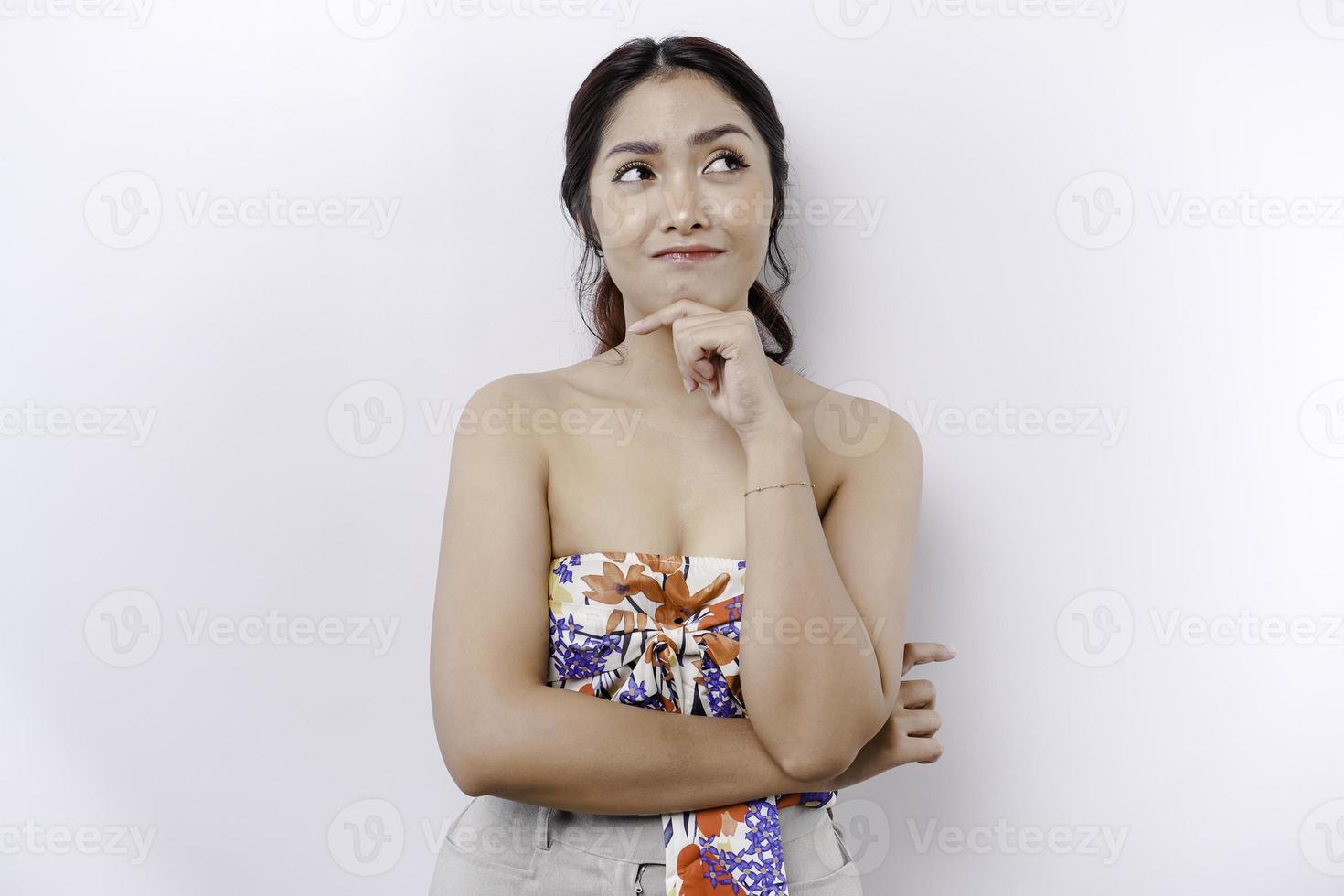 A thoughtful young woman while looking aside, isolated by white background photo