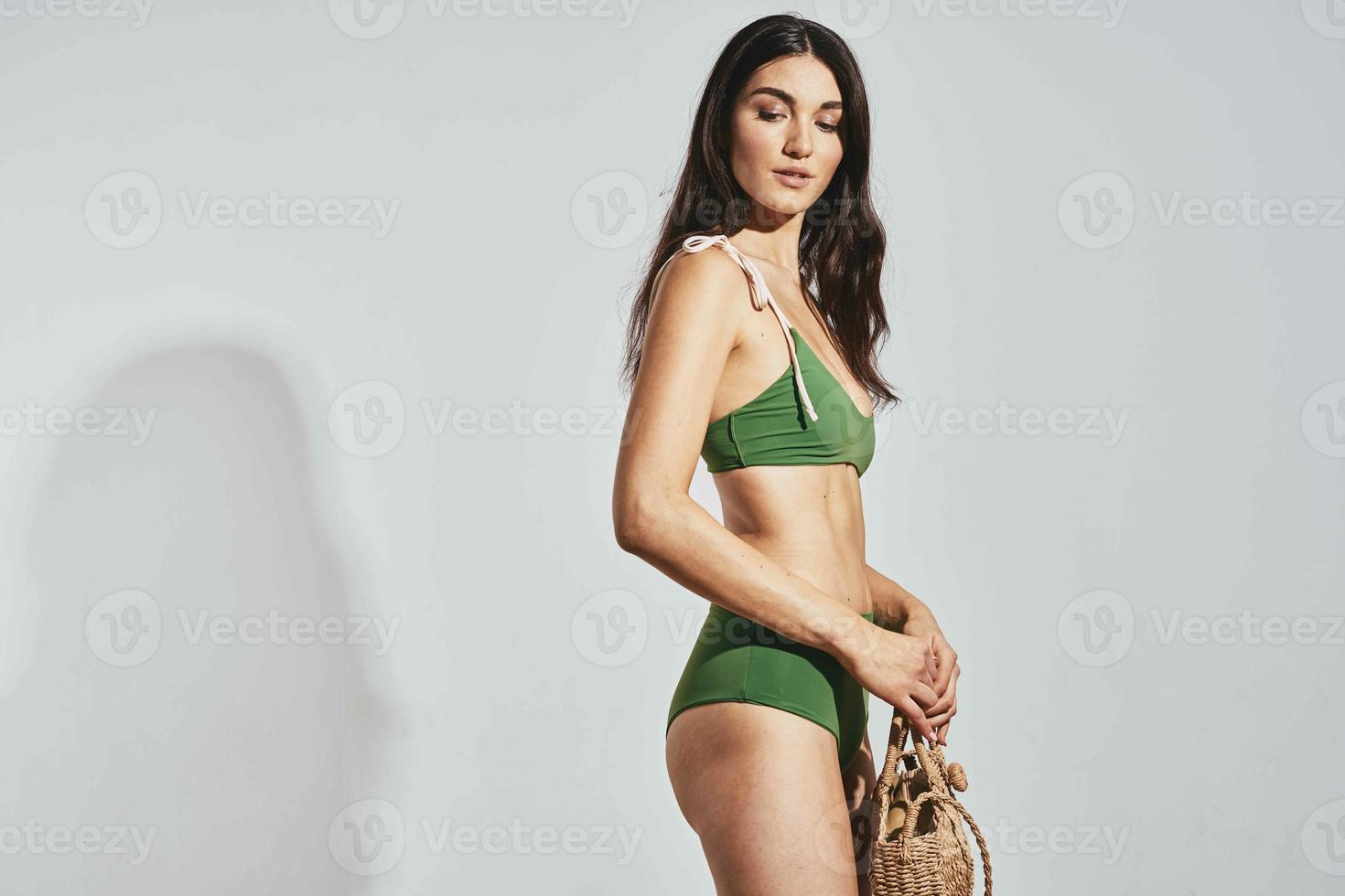 cheerful woman in green swimsuit beach bag travel fashion photo