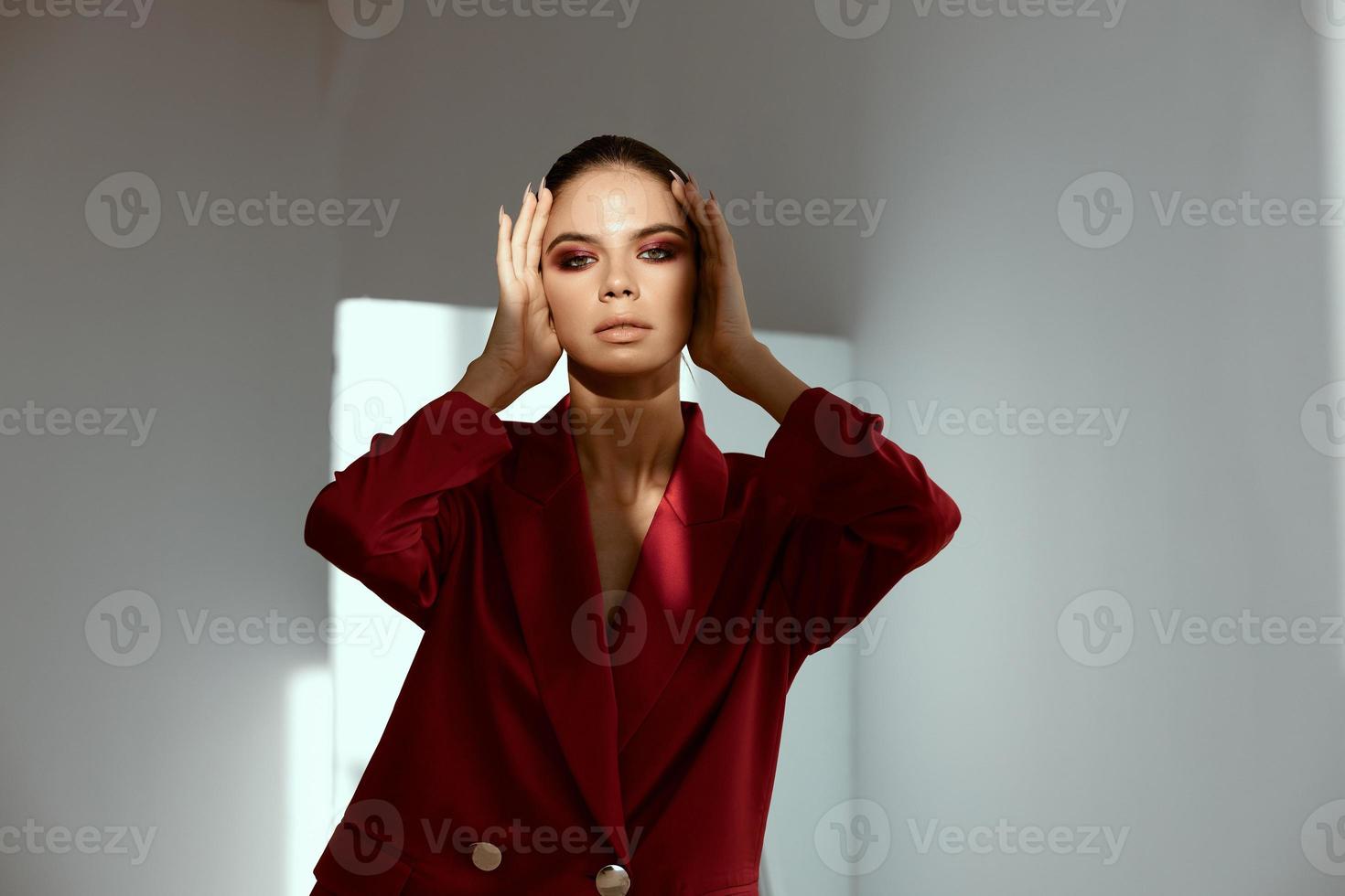extravagant lady with bright makeup on her face touches her head with her hands photo