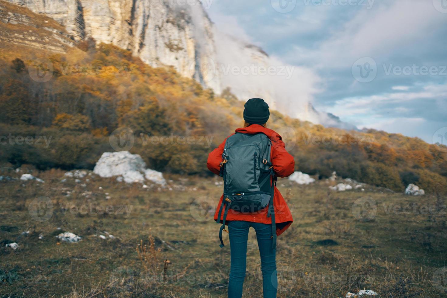 woman model In a red jacket with a backpack in the fall outdoors warm hat photo