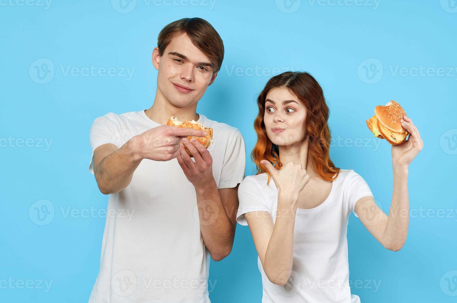 man and woman in t-shirts with hamburgers in the hands of fast food diet photo