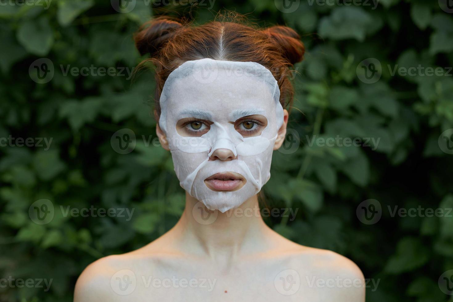 Nice woman Anti-wrinkle mask bare shoulders bushes in the background photo