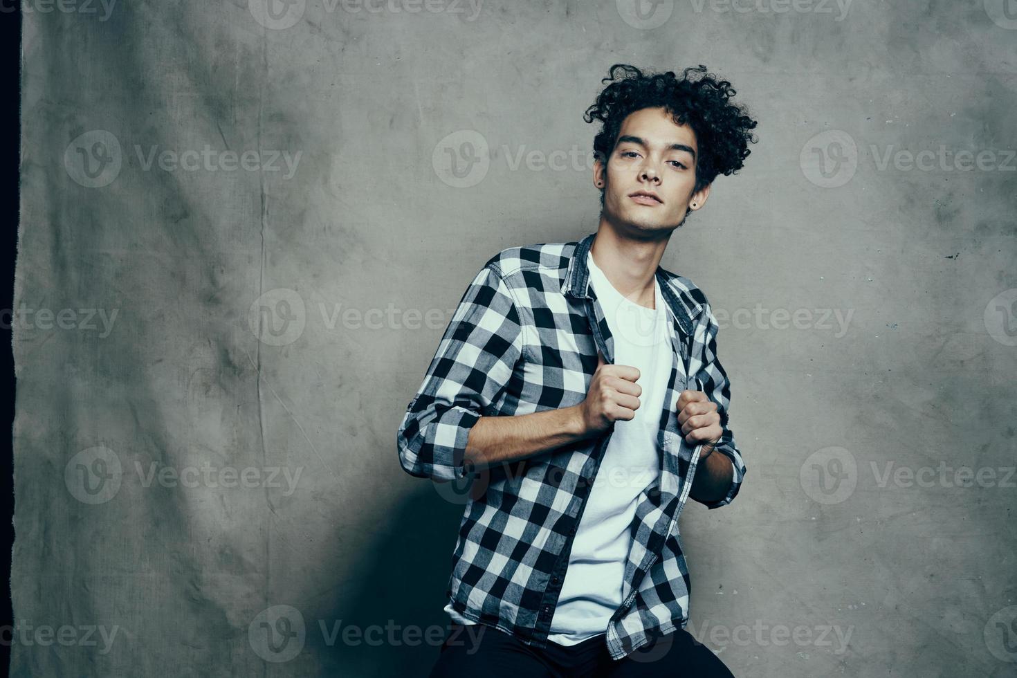 Cheerful guy curly hair plaid shirt Studio gray background photo