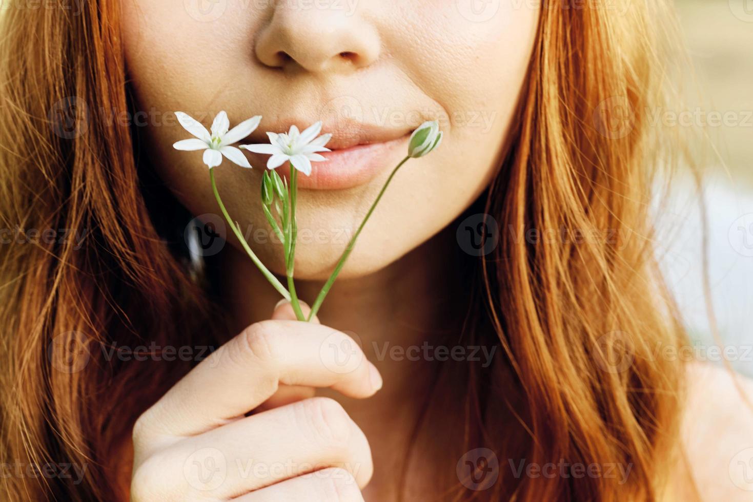 Woman holding a spring flower in her hand in sunlight, conservation and ecology photo