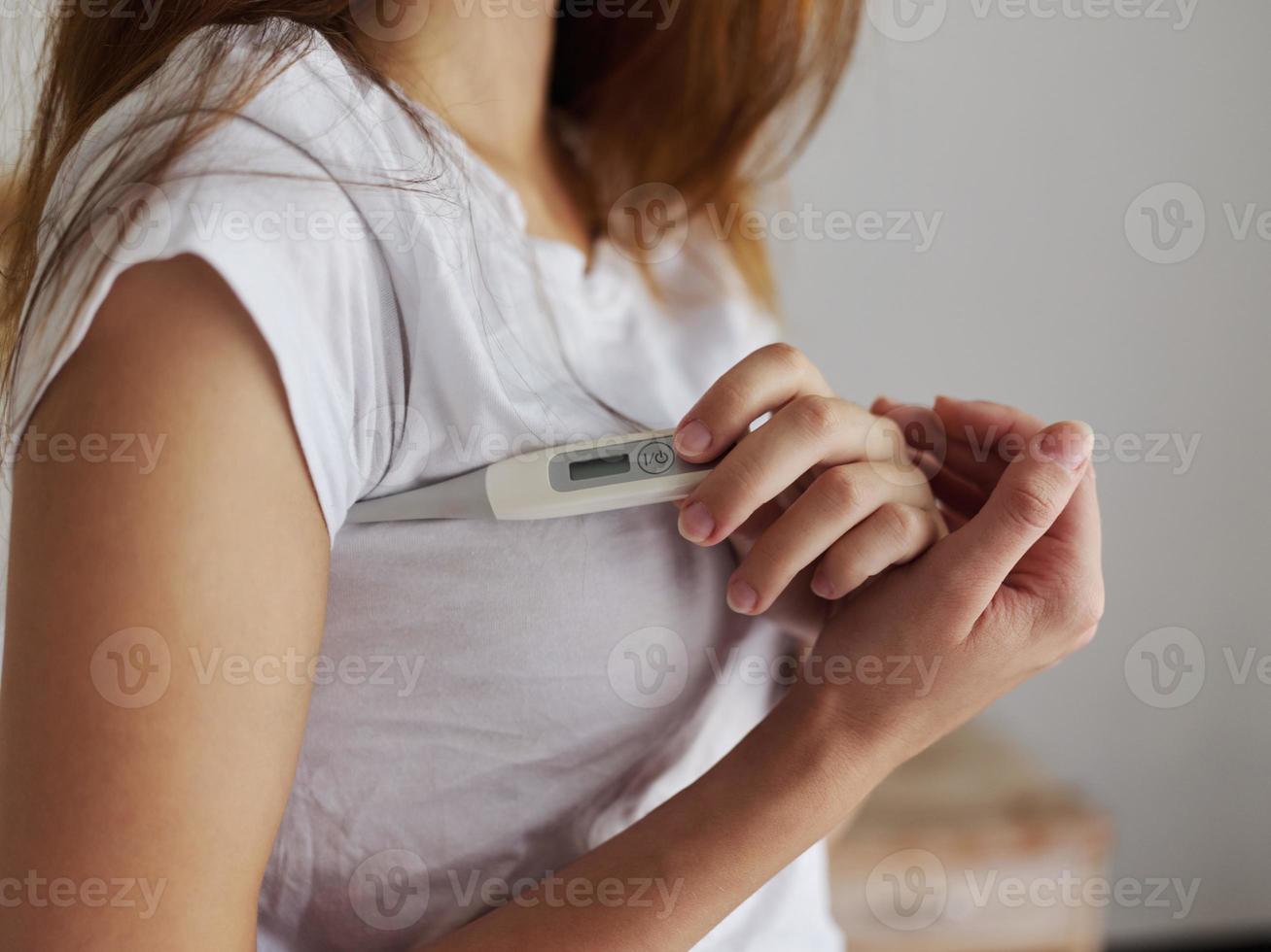woman with armpit thermometer checking temperature close up 21987272
