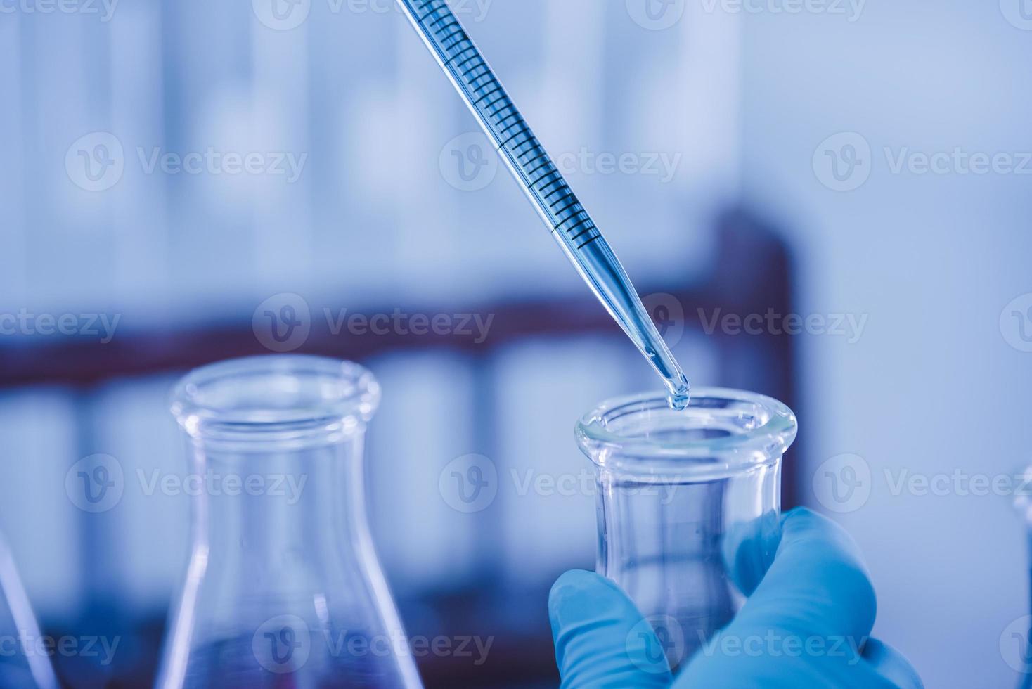 médico o científico utilizando pipeta a soltar un muestra a prueba tubo en médico investigación laboratorio o Ciencias laboratorio foto