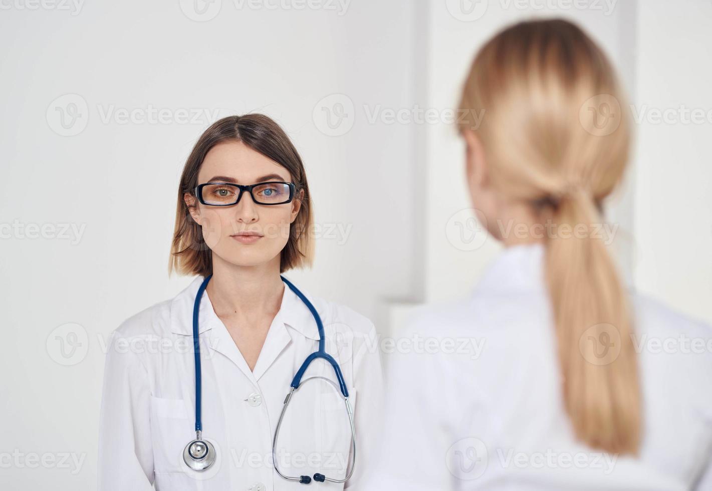 professional doctor with a stethoscope explaining something to a patient in a t-shirt photo