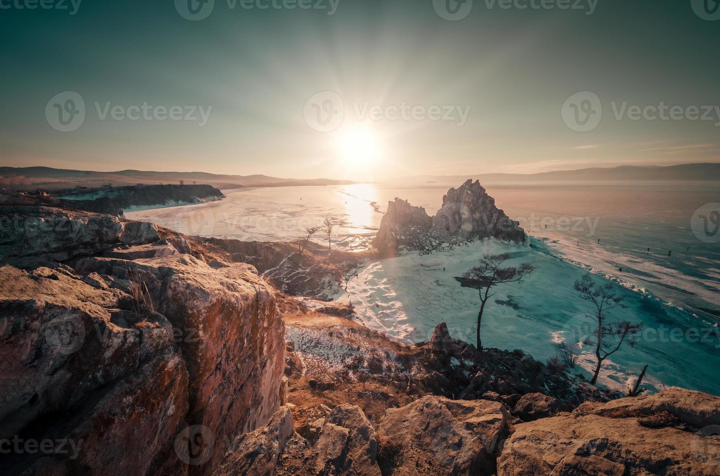 Landscape of Shamanka rock at sunset with natural breaking ice in frozen water on Lake Baikal, Siberia, Russia. photo