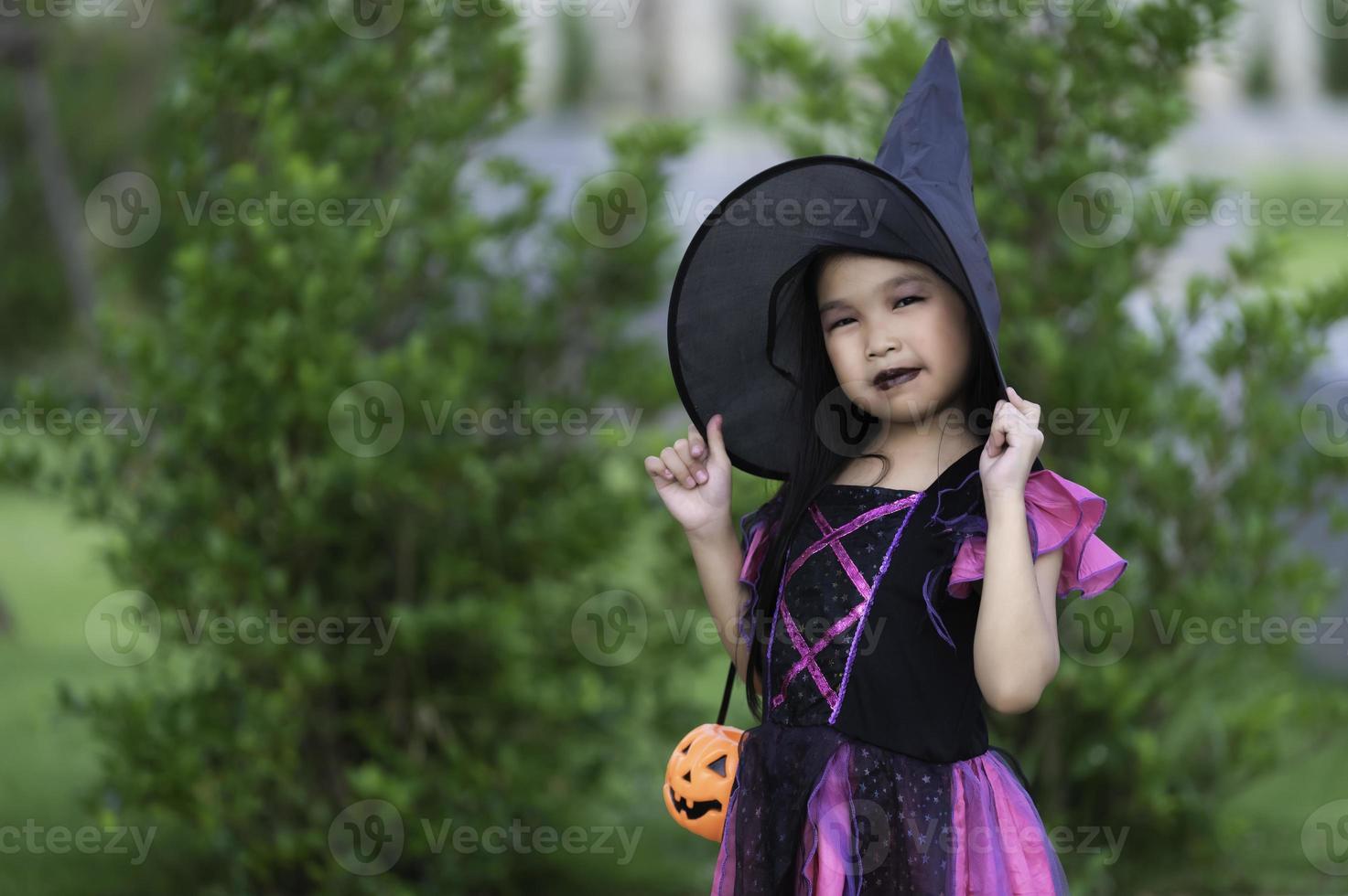 asiático linda hembra niño vestir bruja disfraz con calabaza, halloween festival concepto foto