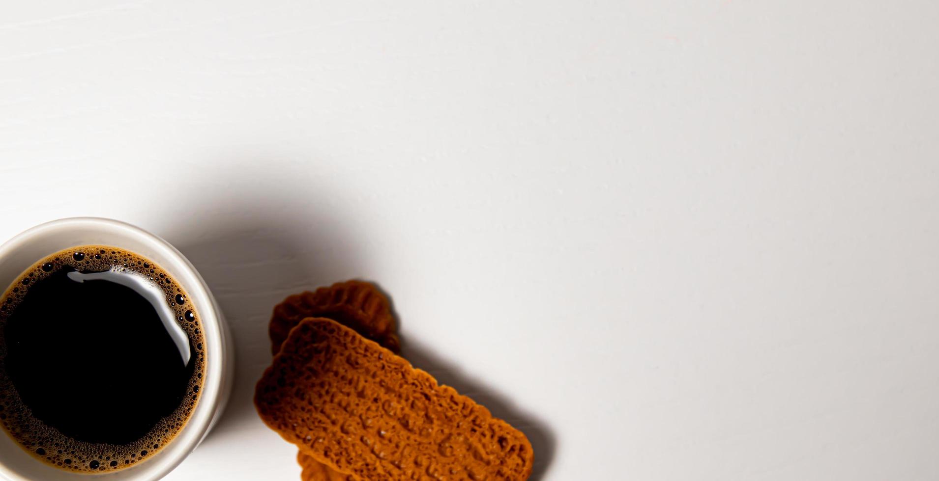 Cup of coffee and cookies on a white background, top view photo