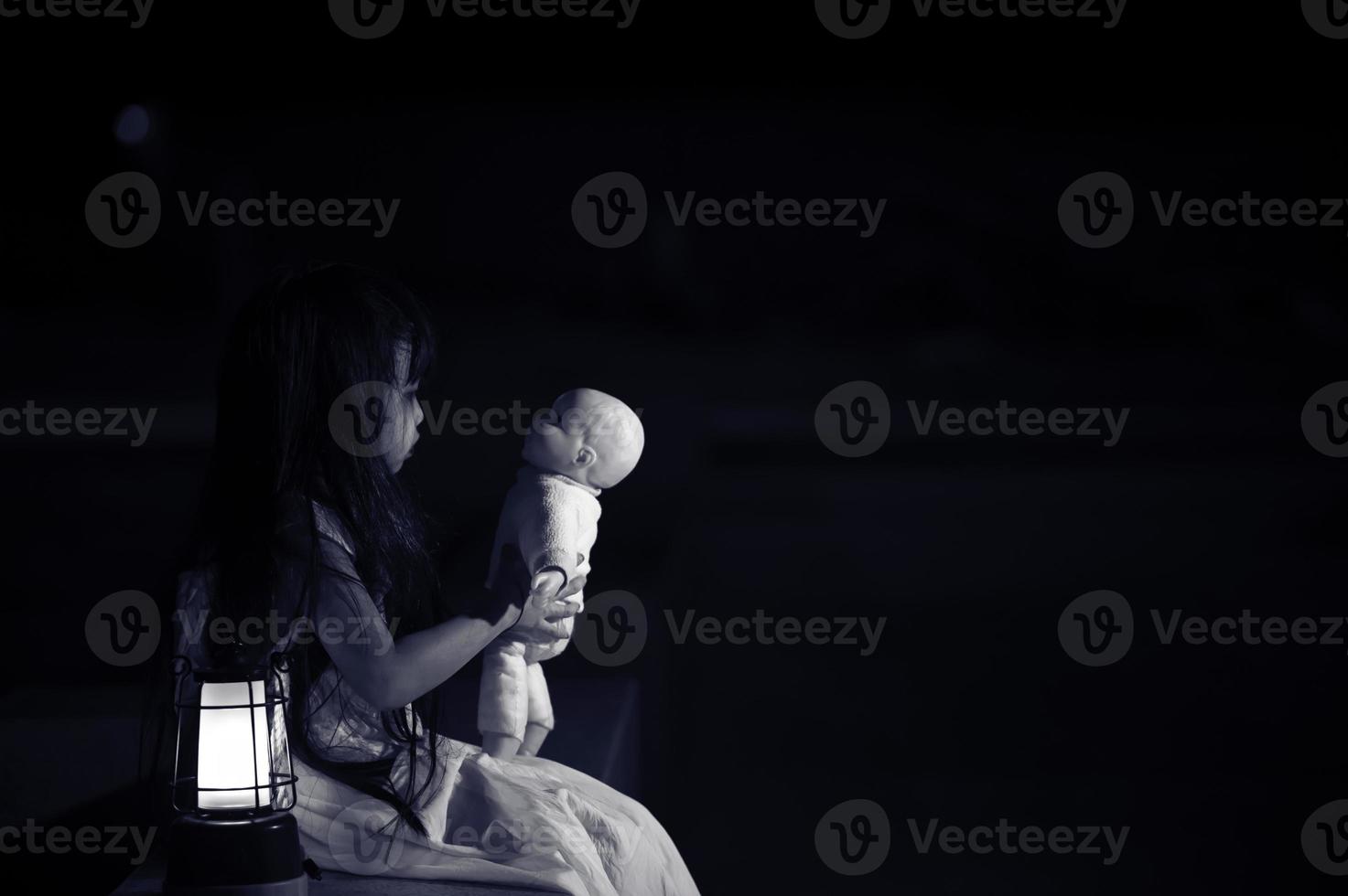 sad child ghost at night,Halloween Festival concept,Friday 13th,Horror movie scene,A girl with doll photo