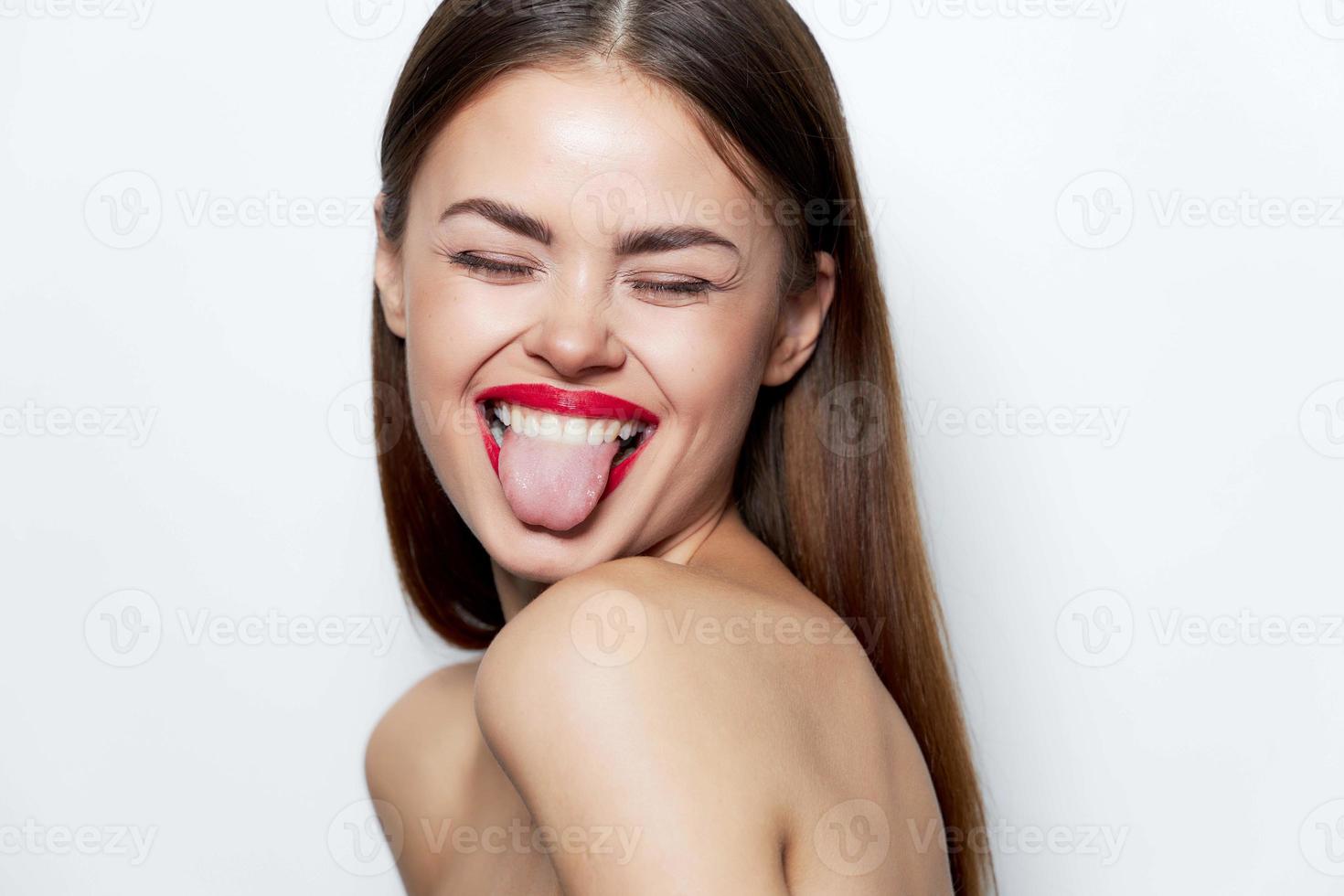 Woman portrait Naked shoulders gaiety closed eyes showing tongue bare shoulders photo