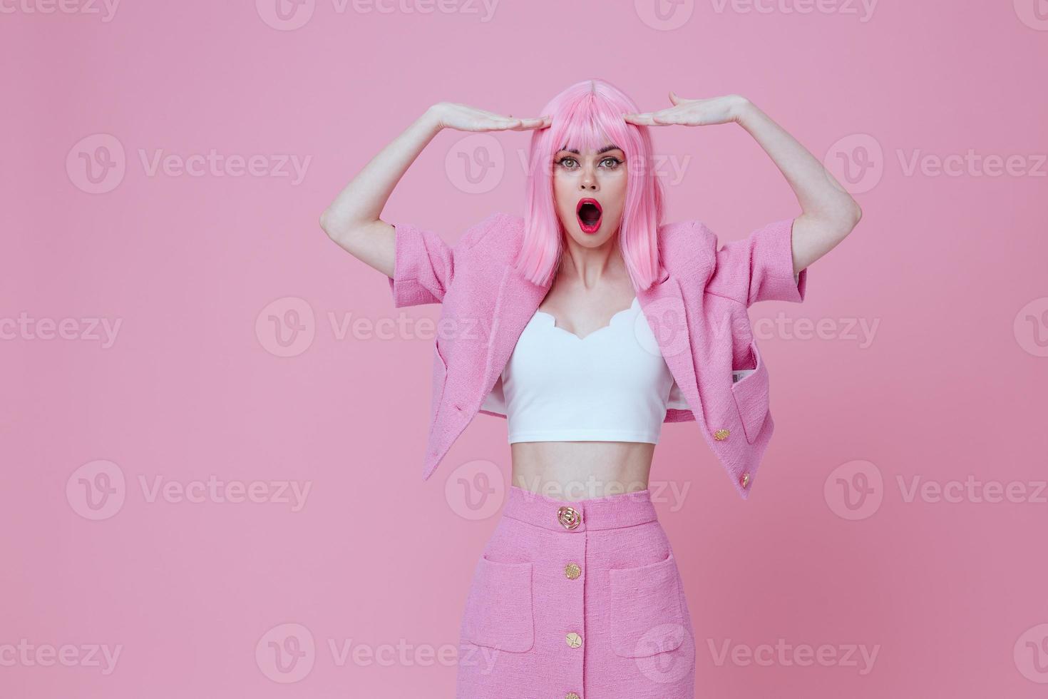 Young positive woman in a pink suit gesturing with his hands emotions fun color background unaltered photo