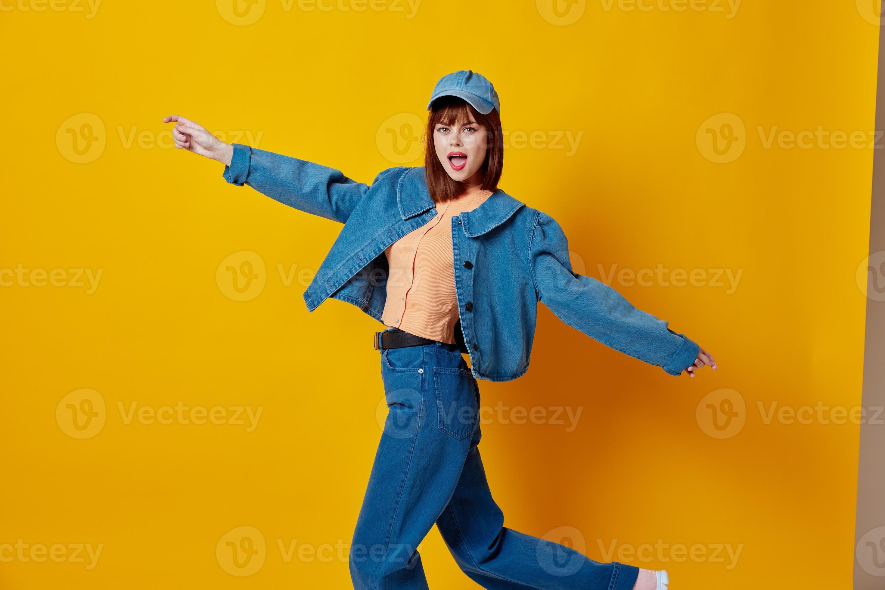 Pretty young female denim clothing fashion posing cap yellow background  unaltered 21988361 Stock Photo at Vecteezy