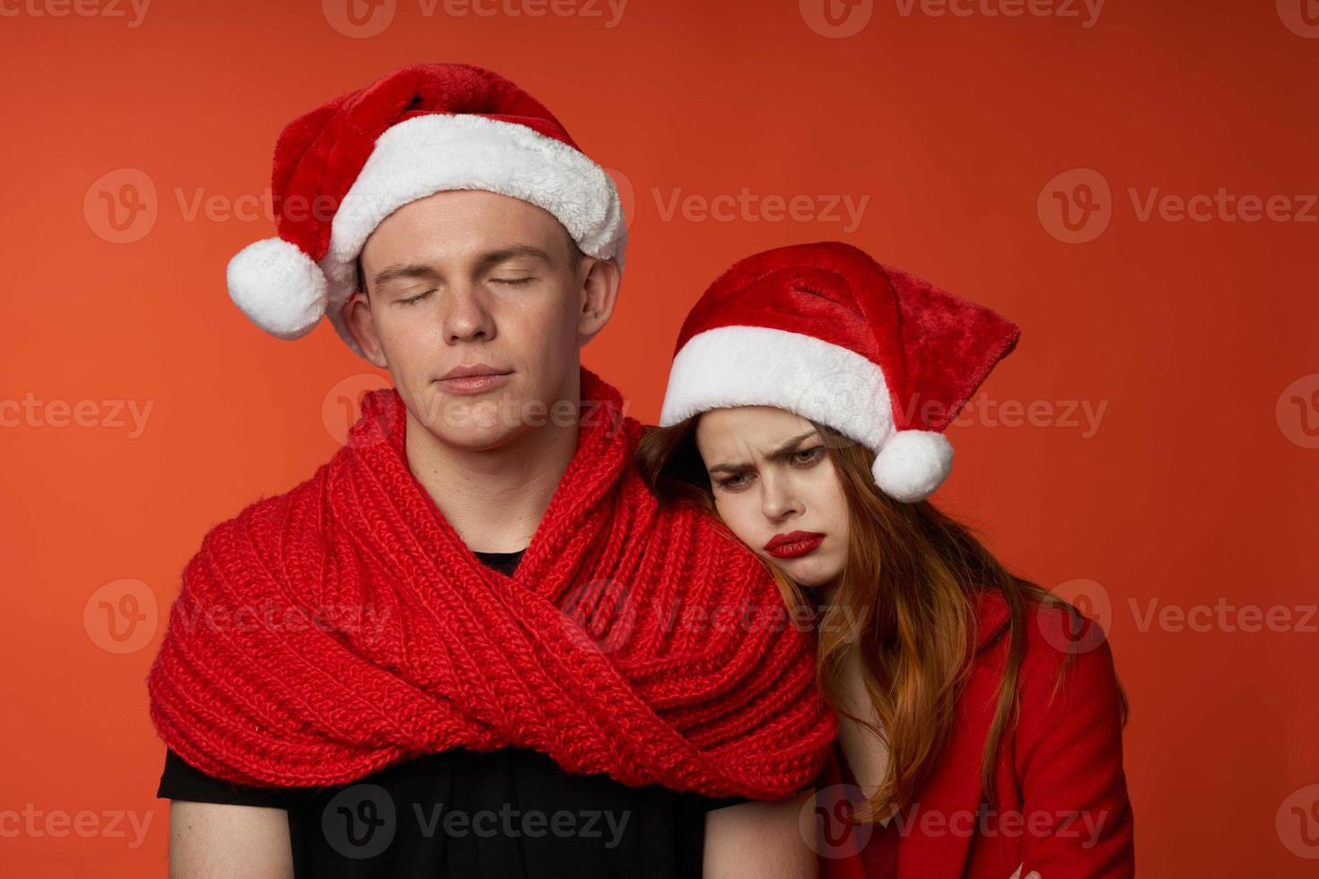 family in santa hats fun new year holiday red background photo