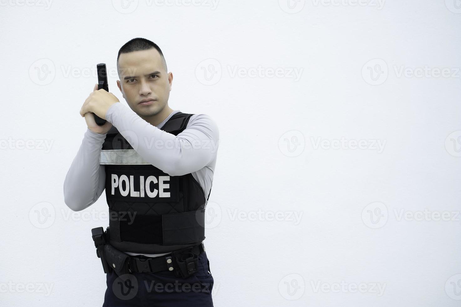 Portrait of police hold gun in hand on white background,Handsome asian cop photo