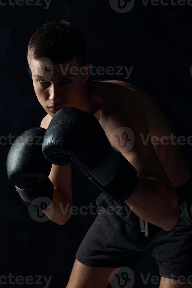 man in boxing gloves on black background workout bodybuilder fitness photo