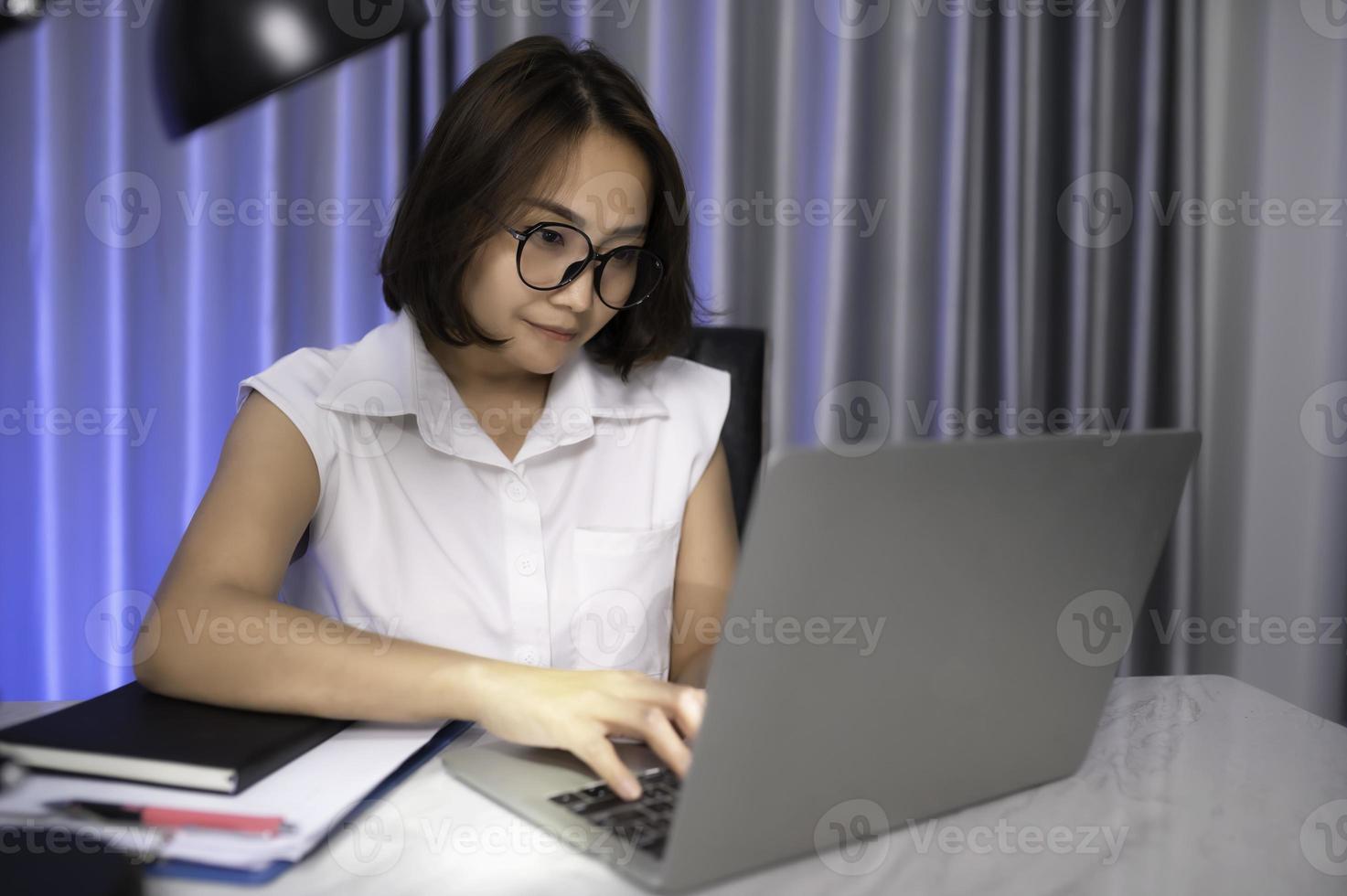 Beautiful asian woman working at home on the night,A lot of work from company,bring home work,Work from home photo