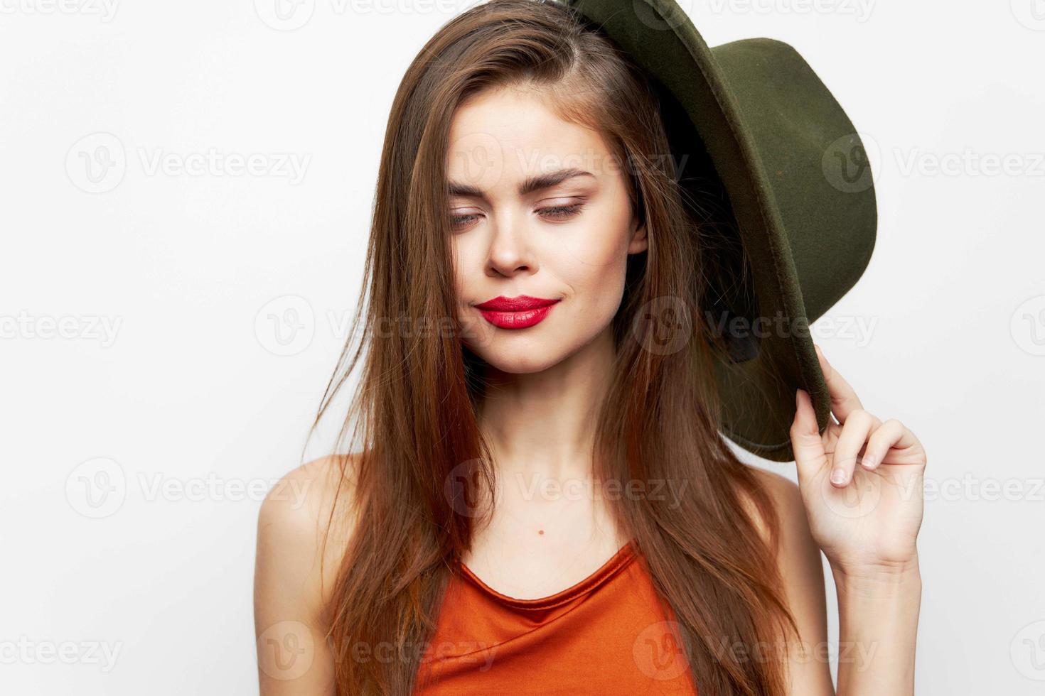 mujer participación sombrero cerrado ojos sonrisa Moda cerca cara rojo vestido de verano foto