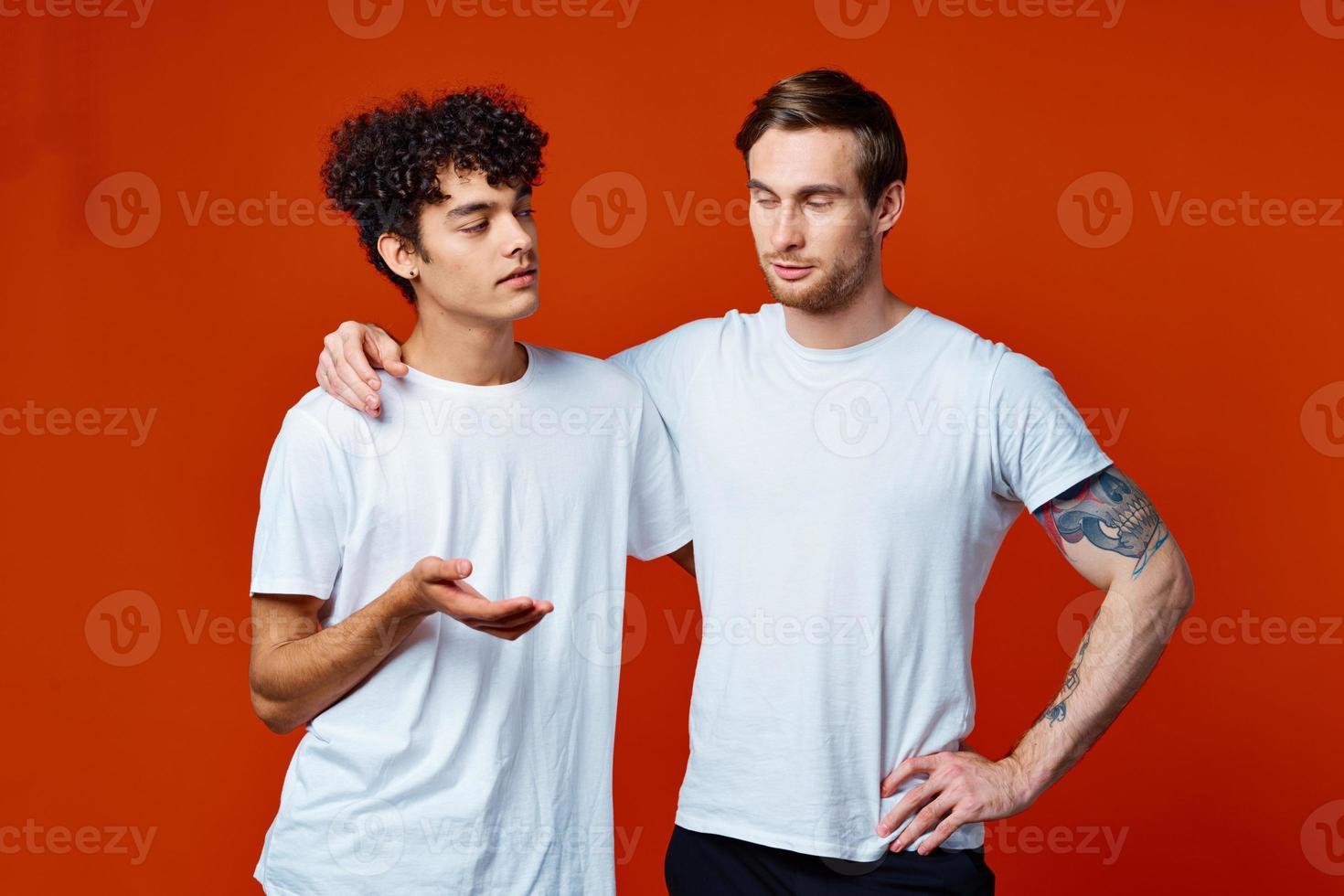 Two cheerful friends in white t-shirts stand side by side photo