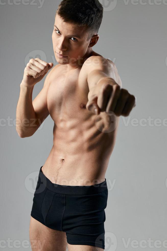 Boxer en un gris antecedentes desnudo torso cubitos en el estómago aptitud foto