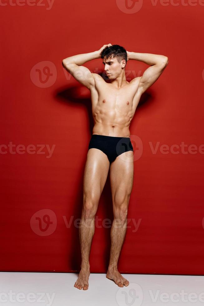 handsome man with a naked torso and black panties and hands behind his head  red background model 21989824 Stock Photo at Vecteezy