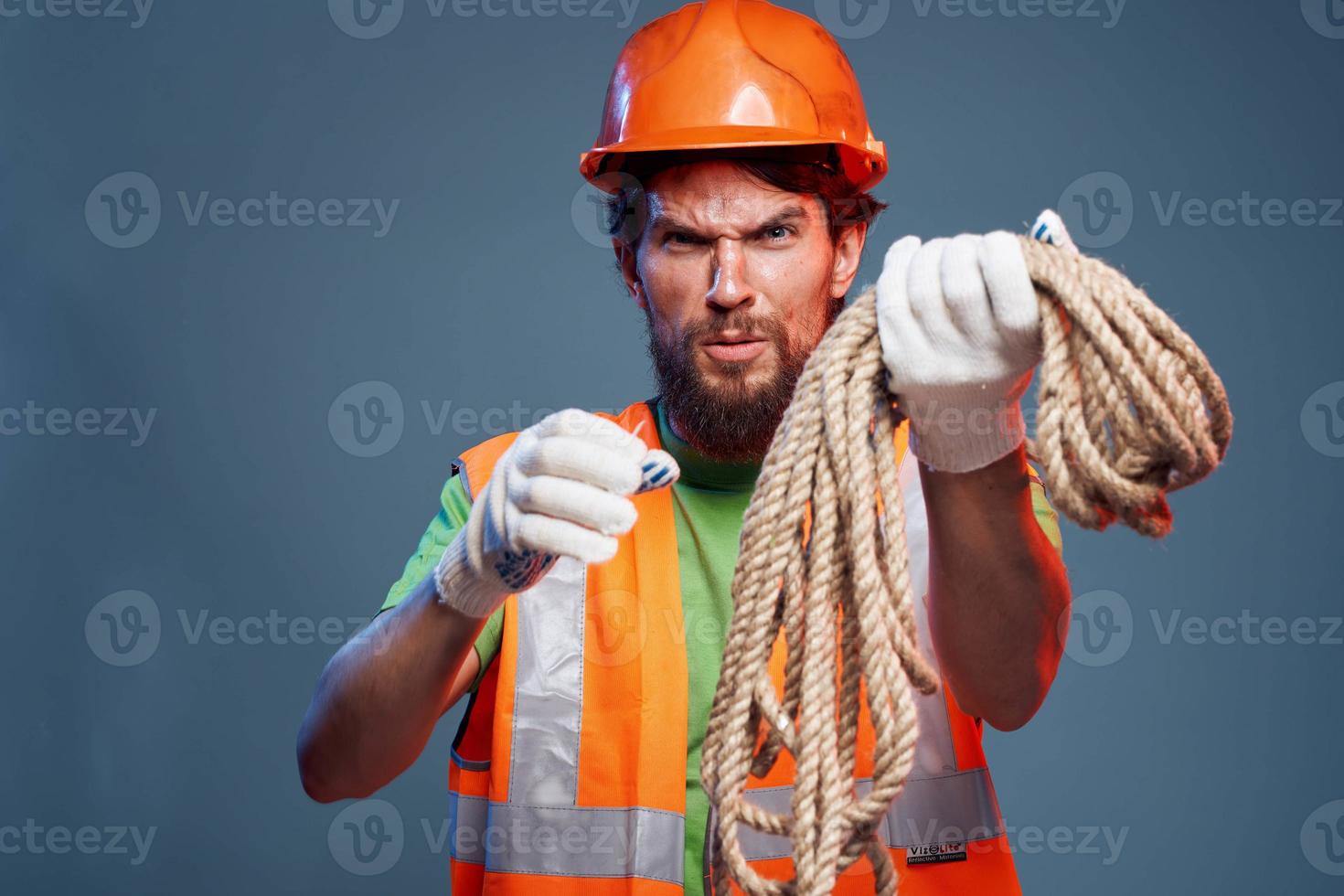 A man in a working uniform with a rope in his hands emotions construction lifestyle photo